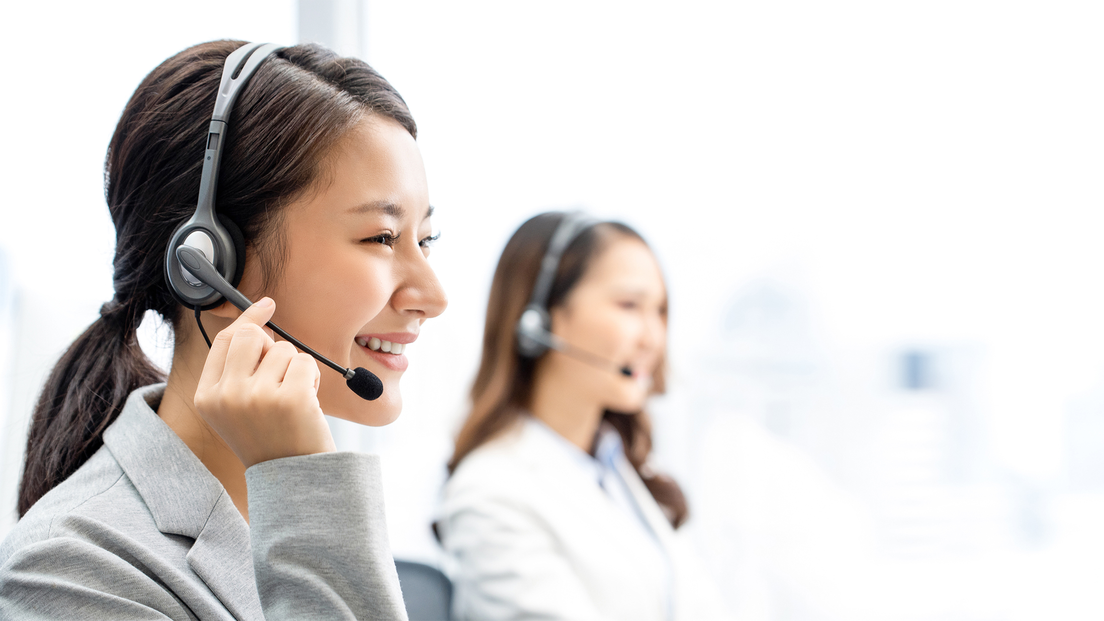 Diverse office workers wear headset with microphone browsing work on pc in coworking space, millennial male call center agent in glasses busy with computer consult client or customer online; Shutterstock ID 1419436334; purchase_order: -; job: -; client: -; other: -