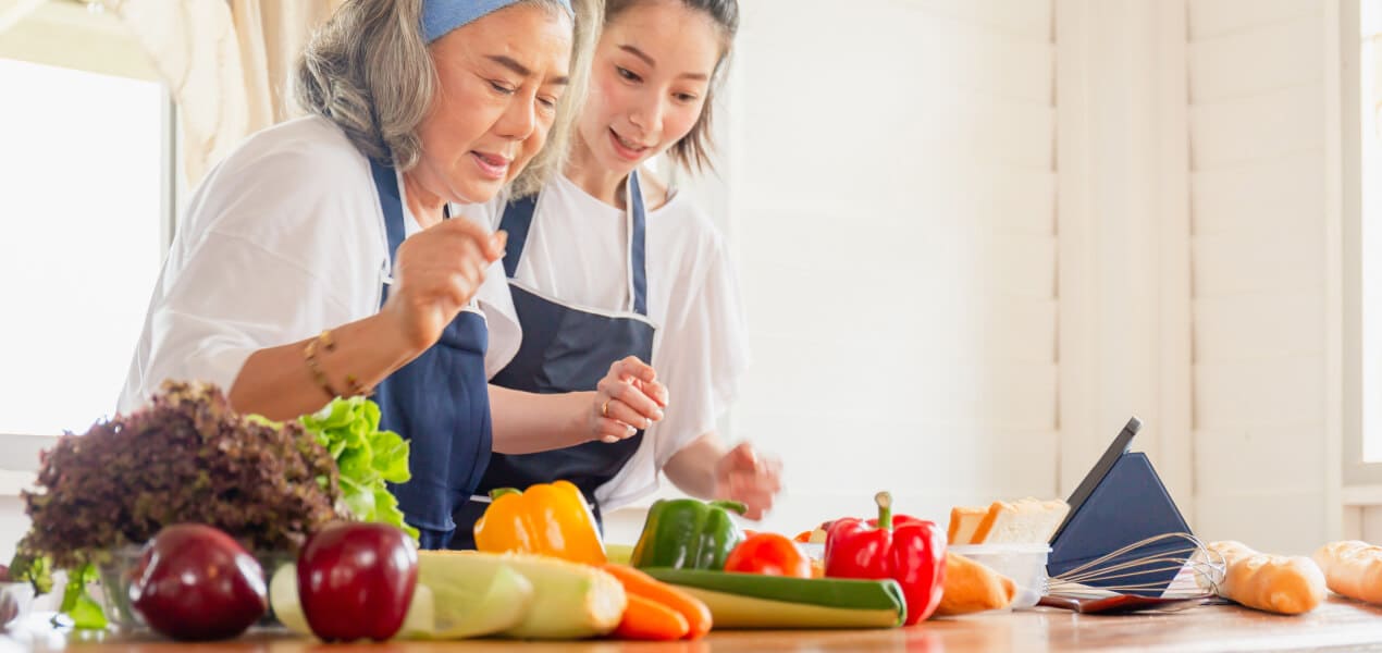 An elderly and young woman with healthy ingredients for dietary management of diabetes